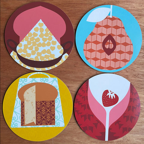 Four round table mats with food and drink designs quince strawberry wine panettone chickpease